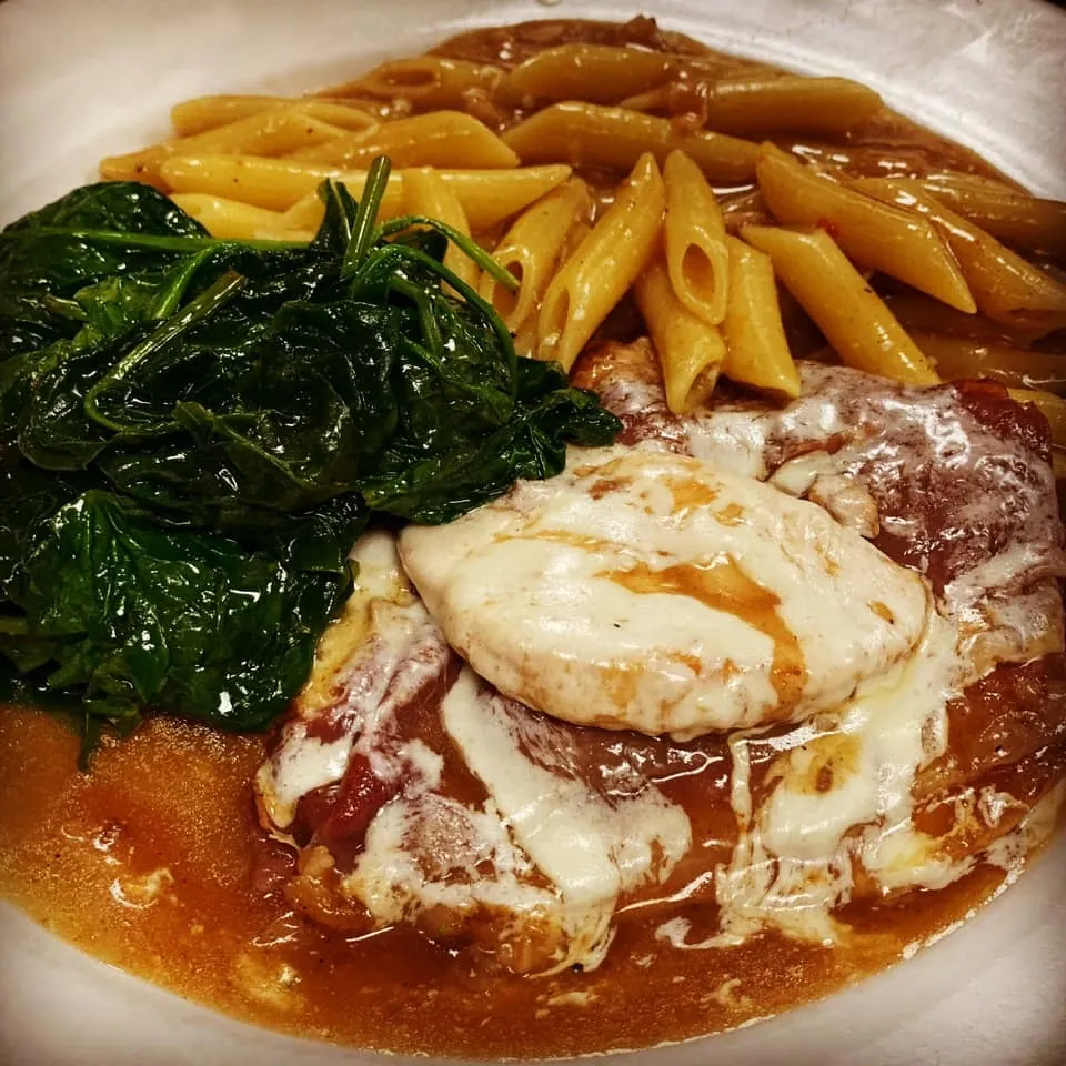 Veal under melted mozzarella with penne and sauteed spinach